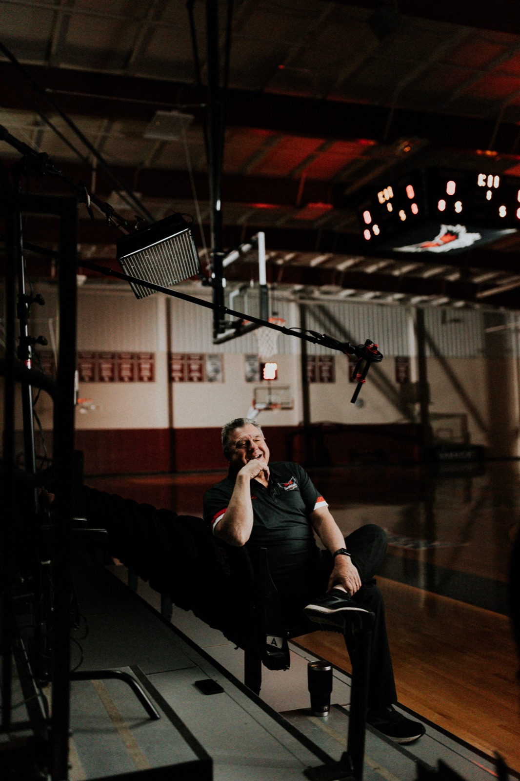 Garth Pleasant laughing courtside between takes during the COACH documentary shoot